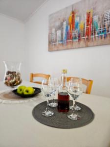 ロヴランにあるSunsetのワイングラスとボトル1本が付いたテーブル