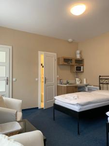 uma sala de estar com uma cama e uma cozinha em Apartma La Provence em Mariánské Lázně
