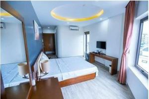 a hotel room with a bed and a mirror at Sen Biển Hotel FLC Sầm Sơn in Sầm Sơn