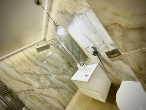 ein Badezimmer mit einem WC, einem Waschbecken und einem Spiegel in der Unterkunft Cozy Place to Stay -Self check in 24h in Reşiţa