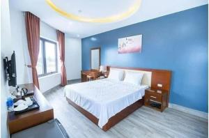 岑山的住宿－Sen Biển Hotel FLC Sầm Sơn，一间卧室设有一张大床和蓝色的墙壁
