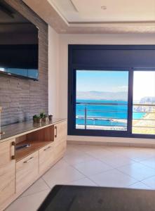 uma cozinha com uma grande janela com vista para o oceano em Appartement Sable Rose em Al Hoceïma