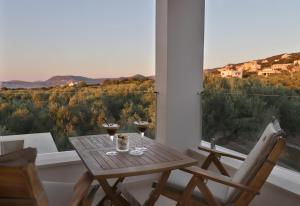 a table with two glasses of wine on a balcony at NiMar Villa in Sitia