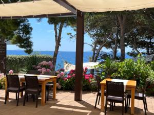 un patio con tavoli, sedie e vista sull'oceano di Villa Ana a Murter
