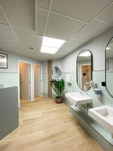 a bathroom with two sinks and a mirror at The POD Suite Hostel in Valencia