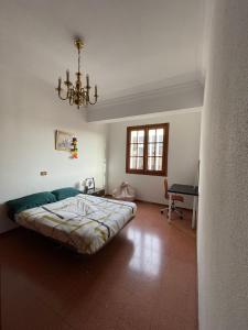 1 dormitorio con cama, escritorio y lámpara de araña en CoLiving El Secretario, en Las Palmas de Gran Canaria