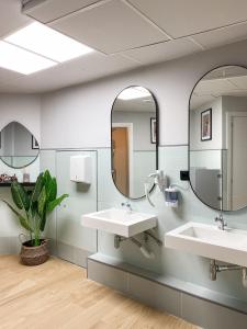 ein Badezimmer mit zwei Waschbecken und zwei Spiegeln in der Unterkunft The POD Suite Hostel in Valencia