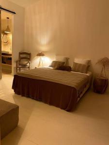 a bedroom with a large bed and a chair at Loft Augustine in Leucate