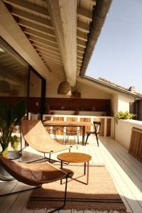 a patio with tables and chairs on a deck at Loft Augustine in Leucate