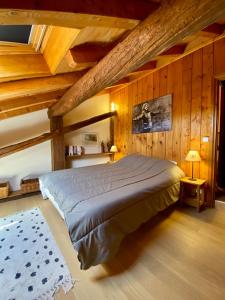 a bedroom with a bed in a room with wooden ceilings at Chalet Fr Gilkens Arc 1600 in Bourg-Saint-Maurice