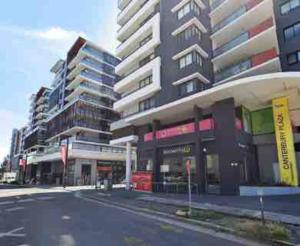 an empty street in a city with tall buildings at Aircabin - Canterbury - Cheerful - 2 Bed Apartment in Sydney