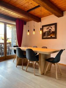 ブール・サン・モーリスにあるChalet Fr Gilkens Arc 1600のダイニングルーム(木製テーブル、椅子付)