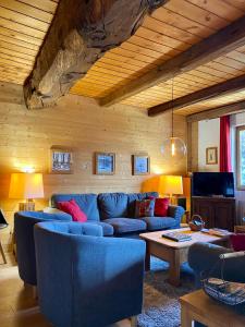 a living room with a blue couch and a table at Chalet Fr Gilkens Arc 1600 in Bourg-Saint-Maurice
