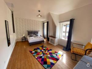 Dormitorio con cama y alfombra colorida en el suelo en La Rose des Sables en Trouville-sur-Mer