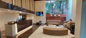 Un hombre de pie en un mostrador en un vestíbulo. en Lytton Hotel, en Calcuta