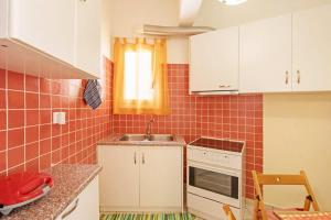 a small kitchen with white cabinets and a sink at Quiet Central apt in picturesque Pagrati in Athens