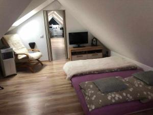 a attic bedroom with a bed and a mirror at Zajazd Ponikiew - Noclegi Wadowice in Wadowice