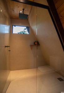 a bathroom with a shower with a glass door at Urutau Pousada in Urubici