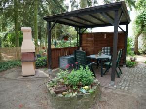 cenador con mesa y sillas en el jardín en Ferienwohnung auf dem Land, en Mellenthin