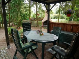 una mesa y sillas en un patio con parrilla en Ferienwohnung auf dem Land, en Mellenthin