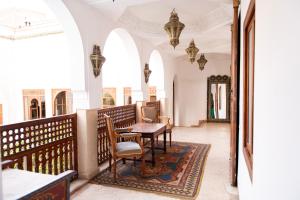 a hallway with a table and chairs in a building at Riad Ben Youssef in Marrakech