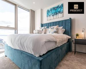 a bedroom with a large bed with a blue headboard at The Lexington Liverpool City Centre 24 Hour Gym At By Your Perfect Stay Short Lets Liverpool in Liverpool