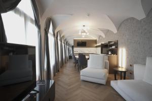 a living room with a white chair and a table at Palazzo Santo Spirito in Bergamo