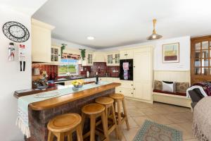 a kitchen with a counter and some wooden stools at Cottage 207 - Ballyconneely in Ballyconneely