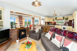 a living room with a couch and a fireplace at Cottage 207 - Ballyconneely in Ballyconneely
