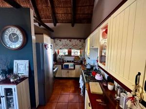eine Küche mit einem Kühlschrank und einer Uhr an der Wand in der Unterkunft A State of Grace in Clanwilliam