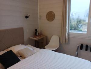 ノワイェ・シュル・シェールにあるHotel de la Gareのベッドルーム1室(ベッド1台、椅子、窓付)