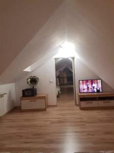 a attic room with a flat screen tv on a table at Zajazd Ponikiew - Noclegi Wadowice in Wadowice