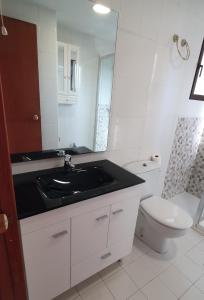 uma casa de banho branca com um lavatório e um WC em Mediterraneo 43 em Benidorm
