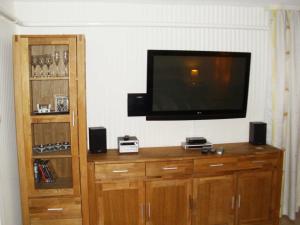 a flat screen tv sitting on top of a wooden entertainment center at Ferienwohnung Am Stadtrand in Sassnitz