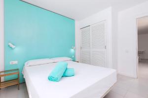 a white bed in a room with a blue wall at Smy Tahona Fuerteventura in Caleta De Fuste