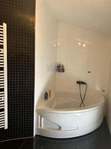 eine weiße Badewanne im Bad mit Spiegel in der Unterkunft Beautiful Villa near Medjugorje in Služanj