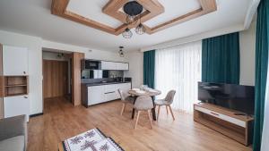 a kitchen and living room with a table and chairs at Resorts L Białka Tatrzańska z sauną, Sun & Snow in Białka Tatrzanska