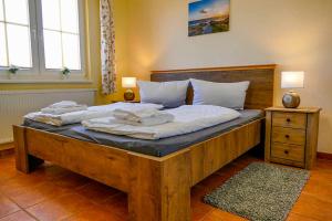 a bedroom with a large wooden bed with white pillows at Ferienwohnungen Kariba und Sammy in Neddesitz