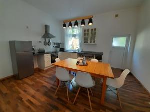 una cucina con tavolo in legno e sedie bianche di KOBLENZ O&O Apartment a Coblenza