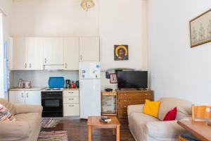 a living room with a couch and a kitchen at Imerios Nisyrian House in Mandrákion