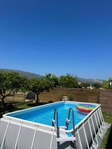 a swimming pool with two chairs next to it at Lovos House in Laganas