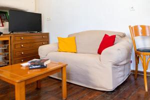 a living room with a white couch with colorful pillows at Imerios Nisyrian House in Mandrákion