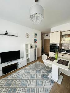a living room with a white table and a rug at Kiki home in Oradea +8 photos