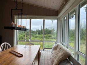 une salle à manger avec une table et une grande fenêtre dans l'établissement Hytte med flott utsikt, à Beitostøl