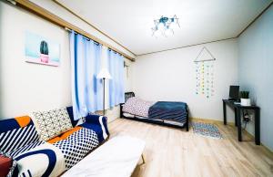una sala de estar con un sofá y una cama en Sweet Stay, en Seúl