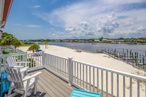 a deck with two chairs and a beach and water at Banana Bay 13912 By Pkrm in Pensacola