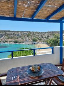 a table on a balcony with a view of a beach at Thalassa house by the sea in Áyios Yeóryios