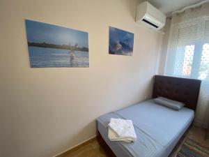 uma pequena cama num quarto com uma fotografia na parede em MINO APARTMENT em Shkodër