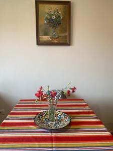 uma mesa com um vaso de flores sobre uma mesa em MINO APARTMENT em Shkodër