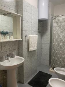 La salle de bains est pourvue d'un lavabo et de toilettes. dans l'établissement MINO APARTMENT, à Shkodër